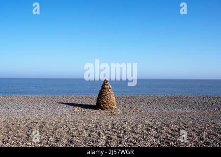 North Sea Sentinel è un tradizionale cairn creato da Henry Fletcher utilizzando pietra di aragia corallina di origine locale che è stato esposto da erosione costiera. Foto Stock