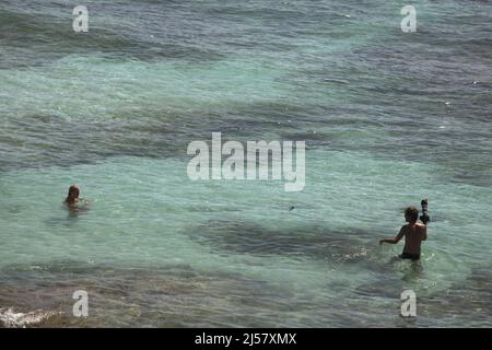 Un fotografo sta per scattare foto di una donna sulla spiaggia di Padang-padang a Labuan Sait, South Kuta, Bali, Indonesia. Foto Stock