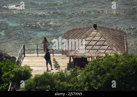 Persone che hanno un tempo libero su un ponte di legno sopra la spiaggia di Padang-padang a Labuan Sait, Kuta Sud, Bali, Indonesia. Foto Stock