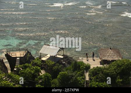 Persone che hanno un tempo libero su un ponte di legno sopra la spiaggia di Padang-padang a Labuan Sait, Kuta Sud, Bali, Indonesia. Foto Stock