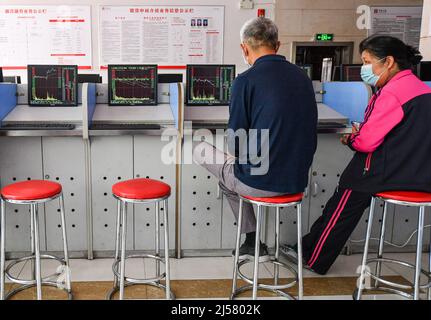 Fuyang, Cina. 21st Apr 2022. Gli investitori anziani guardano il mercato delle Azioni A in Cina presso un ufficio titoli a Fuyang. Le azioni cinesi hanno chiuso più in basso giovedì, con il benchmark Shanghai Composite Index in calo del 2,26%, a 3.079,81 punti. Il Shenzhen Component Index ha chiuso il 2,7% in meno a 11.084,28 punti. Credit: SOPA Images Limited/Alamy Live News Foto Stock