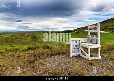 Due lattine di latte pronte per la raccolta, pubblicità di fronte ad una fattoria, latticini per gelato, grattacielo, formaggio, Erpsstadir, Erpsstaoir, Buoardalur Foto Stock