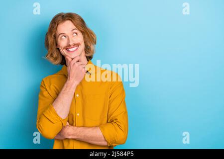 Ritratto di attraente mentalità allegro ragazzo a capelli lunghi decidendo copia spazio vuoto isolato su sfondo di colore blu brillante Foto Stock