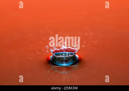 Tropfenfotografie, Wassertropfen caduto auf Wasseroberflaeche, Wassersaeule, Farbenspiel, Studioaufnahme Foto Stock