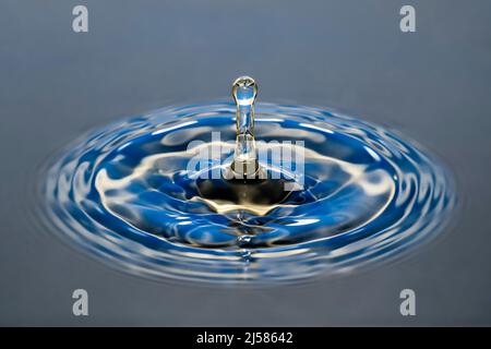 Tropfenfotografie, Wassertropfen caduto auf Wasseroberflaeche, Wassersaeule, Farbenspiel, Studioaufnahme Foto Stock