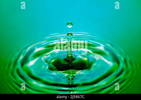 Tropfenfotografie, Wassertropfen caduto auf Wasseroberflaeche, Wassersaeule, Farbenspiel, Studioaufnahme Foto Stock
