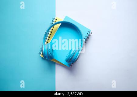 Concetto di audiolibro. Cuffie e blocco note sul tavolo Foto Stock