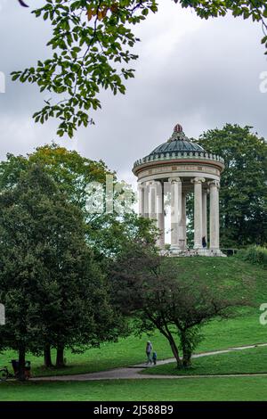 Uomo e bambino che camminano nel Giardino Inglese di Monaco di fronte al Monopteros, Germania Foto Stock