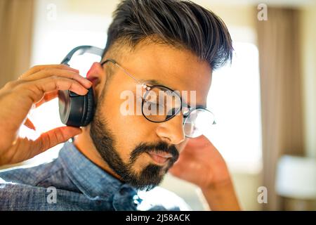 bearded uomo arabo ascolto audio meditazione business formazione crescita personale in nuovo appartamento Foto Stock