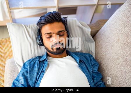 bearded uomo arabo ascolto audio meditazione business formazione crescita personale in nuovo appartamento Foto Stock