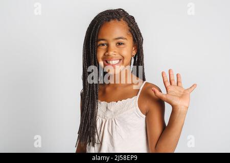 Adorabile bambina africana su sfondo bianco studio dire ciao Foto Stock