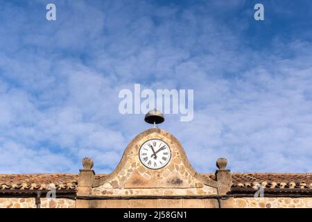 vecchia scuola con orologio e campana. su una città medievale in spagna Foto Stock