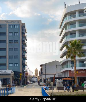 LARNAKA, CIPRO - 18 FEBBRAIO 2019: Persone a piedi dalla passeggiata della città di Larnaca. Edifici dell'hotel. Chiesa di San Lazzaro sullo sfondo. Cipro Foto Stock