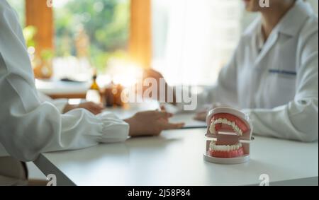 dentista e paziente discussione sul trattamento previsto dei denti in studio medico dentale - concetto di consulenza dentista Foto Stock