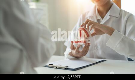 dentista e paziente discussione sul trattamento previsto dei denti in studio medico dentale - concetto di consulenza dentista Foto Stock