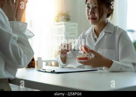 dentista e paziente discussione sul trattamento previsto dei denti in studio medico dentale - concetto di consulenza dentista Foto Stock