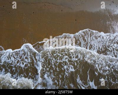 Vista aerea verso il basso delle onde che si lavano sulla spiaggia Foto Stock
