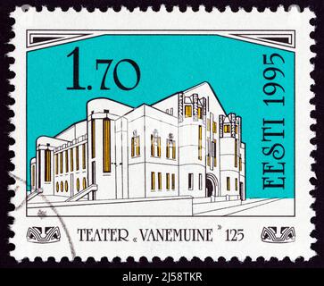 ESTONIA - CIRCA 1995: Un francobollo stampato in Estonia pubblicato per il 125th anniversario del Teatro Vanemuine mostra Vanemuine Teatro vecchio edificio a Tartu, Foto Stock