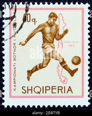 ALBANIA - CIRCA 1966: Un francobollo stampato in Albania dal numero 'Coppa del mondo di calcio - Inghilterra' mostra il calciatore e la mappa del Cile (1962). Foto Stock