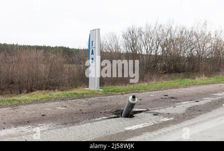 Guerra in Ucraina. Un razzo inesploso si è rotto attraverso l'asfalto sulla strada. Tracce dell'invasione dell'esercito russo dell'Ucraina sulla strada nei pressi di Chernihiv. Foto Stock