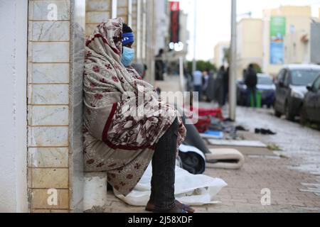 Tunisia. 21st Apr 2022. Decine di rifugiati e migranti in Tunisia chiedono evacuazione in altri paesi. I rifugiati, per lo più sopravvissuti ai tentativi di immigrazione clandestina via mare in Europa, hanno organizzato un sit-in davanti all'ufficio dell'Alto Commissariato delle Nazioni Unite per i rifugiati (UNHCR) nella capitale tunisina, Tunisi da sabato.'dobbiamo essere evacuati,' legge un banner che hanno appeso all'ingresso dell'edificio di Tunisi, Tunisia, il 21 aprile 2022. (Foto di Mohamed KRIT/ Credit: Sipa USA/Alamy Live News Foto Stock