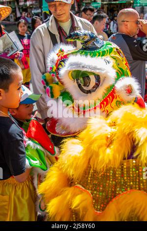 Due ragazzi che si affacciano sulla faccia di un drago Una celebrazione di strada nel quartiere Chinatown di San Francisco Foto Stock