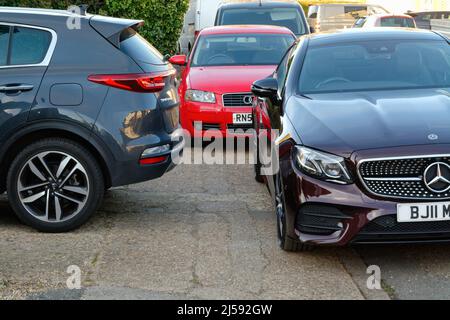 Tre auto mal parcheggiate che bloccano l'accesso a un marciapiede pedonale su una strada suburbana, Inghilterra Regno Unito Foto Stock