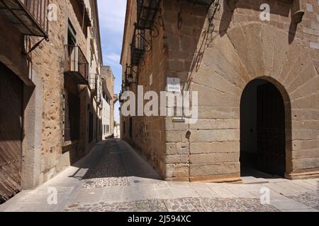 Vicolo stretto Calle Tiendas con Palacio Y Torre Carvajal Palace a Caceres, Extremadura, Spagna Foto Stock