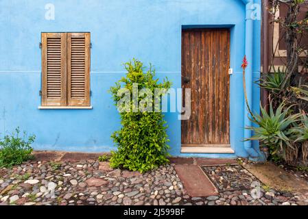 Porta e finestra in legno su parete blu, Bosa, Sardegna, Italia Foto Stock