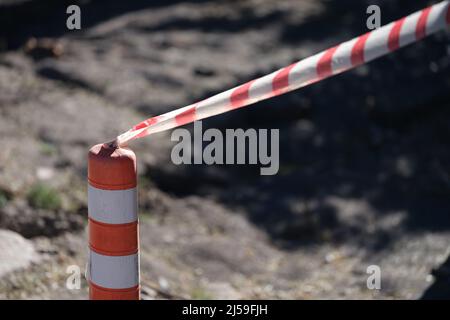 Nastro rosso e bianco teso di fronte al primo piano della zona di pericolo Foto Stock