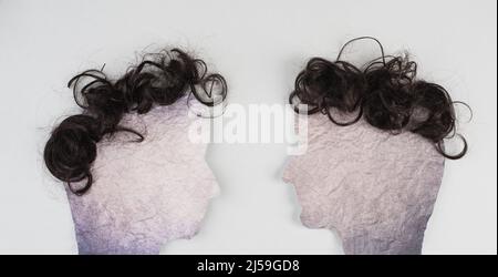 Silhouette di due facce con capelli che si guardano l'un l'altro, la comunicazione, avere un'opinione e una discussione, la libertà di parola, la gente che parla Foto Stock