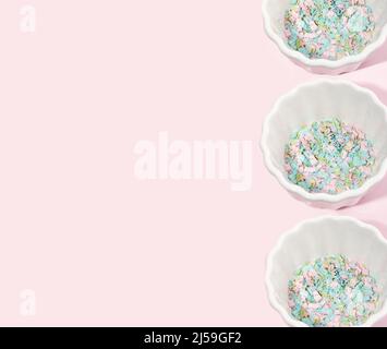 Diverse ciotole piene di microplastica su sfondo rosa. Impatto della micro plastica nella catena alimentare. Il concetto di inquinamento plastico. Foto Stock