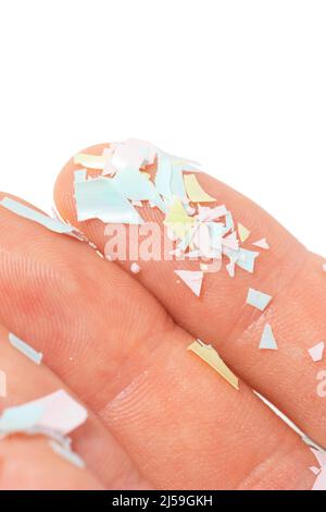 Una foto ravvicinata di microplasti si trova sulla mano umana. Concetto di inquinamento idrico e riscaldamento globale. L'idea del danno ambientale. Sfondo bianco Foto Stock