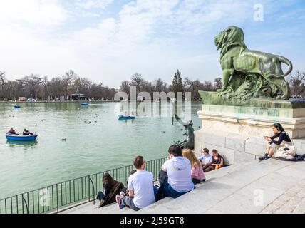 I turisti giovani si siedono vicino allo stagno nel Parco El Retiro, Madrid, Spagna Foto Stock