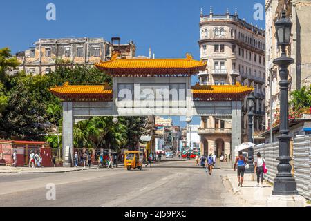 La gente cubana è vista nel loro stile di vita quotidiano dal paifang di Chinatown. Edifici residenziali vecchi, intemperie e scentrati sono visti sullo sfondo Foto Stock