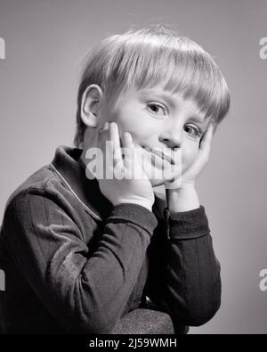 1960S SIMPATICO RAGAZZO BIONDO CHE TIENE LA TESTA NELLE MANI GUARDANDO LA MACCHINA FOTOGRAFICA - J12330 HAR001 HARS ISPIRAZIONE DI MEZZA LUNGHEZZA MASCHI FIDUCIA ESPRESSIONI B&W OCCHIO CONTATTO SOGNI FELICITÀ SCOPERTA ALLEGRA LA SUA CONOSCENZA INTELLIGENTE ORGOGLIO MISCHIEVOUS SORRISI CONCETTUALI IMP CURIOSO IMMAGINAZIONE GIOIOSO ELEGANTE DEVILISH PIACEVOLE PIACEVOLE AFFASCINANTE COOPERAZIONE CREATIVITÀ CRESCITA GIOVANI LOVABLE PERSONABLE PIACEVOLE CONVIVENZA ADORABILE ATTRAENTE BIANCO E NERO CAUCASICO ETNIA HAR001 VECCHIO STILE Foto Stock