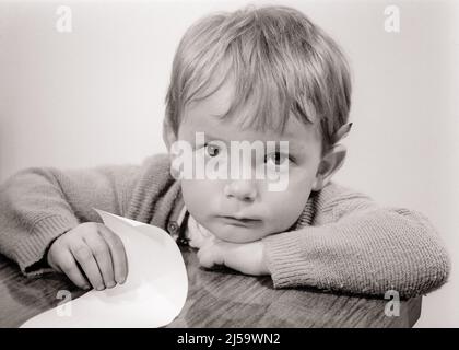 1960S RAGAZZO SERIO SAD PICCOLO GUARDANDO VERSO L'ALTO LA MACCHINA FOTOGRAFICA CHE TIENE UN PEZZO DI CARTA MATITA DIETRO LA NOTA DELL'ORECCHIO DALL'INSEGNANTE TO DO LIST - J12441 HAR001 HARS NOTE MINORILE ELEMENTARE VISO PAURA COMUNICAZIONE PROBLEMI INFORMAZIONI PREOCCUPAZIONE ASTRATTO PEZZO LIFESTYLE STUDIO SHOT MOODY HOME VITA COPIA SPAZIO RELAZIONE PREMUROSO MASCHI ESPRESSIONI DISTURBATO B&W PREOCCUPATO TRISTEZZA OCCHIO CONTATTO SCUOLE TESTA E GRADO SPALLE ALTO ANGOLO IN SU UMORE PRIMARIO GLUM CONCETTUALE SOSTEGNO SINCERO SOLENNE CONCENTRATO SCUOLA DI GRADO INTENSO GIOVANI GUARDANDO IN SU NERO MISERABILE E BIANCO ATTENTO ETNIA CAUCASICA SERIAMENTE HAR001 INTENTI Foto Stock