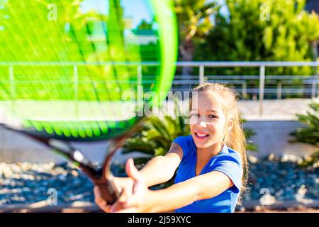 piccola girata che gioca a tennis in un luogo tropicale all'aperto Foto Stock