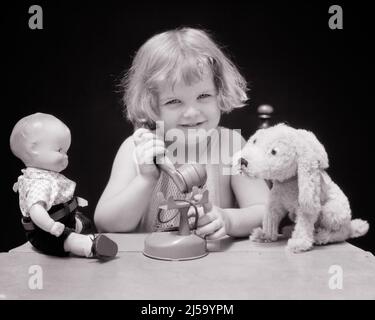 1920S 1930S SORRIDENTE BAMBINA CHE PARLA SU TOY TELEFONO CON IL SUO CANE RIPIENO TOY E BAMBOLA CHE ASCOLTA - J5408 HAR001 HARS HOME VITA COMUNICANTE SPAZIO COPIA CONFIDENZA B&W OCCHIO CONTATTO FELICITÀ TESTA E SPALLE ALLEGRO E TELEFONI SORRIDE TELEFONI IMMAGINAZIONE GIOIOSO PIACEVOLE PIACEVOLE PIACEVOLE AFFASCINANTE CRESCITA GIOVANI LOVABLE PIACEVOLE ADORABILE ATTRAENTE BIANCO E NERO ETNIA CAUCASICA HAR001 VECCHIO STILE Foto Stock