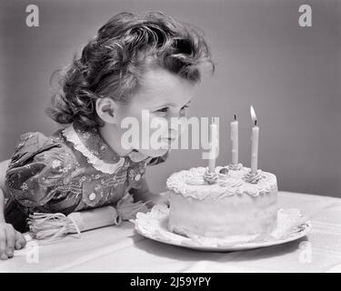 1930S 1940S RAGAZZA CARINA DI TRE ANNI CHE SOFFIA FUORI LE CANDELE SULLA TORTA DI COMPLEANNO CHE FA UN DESIDERIO - J5443 HAR001 HARS COPY SPACE WISHING B&W BRUNETTE CELEBRARE LA FELICITÀ TESTA E SPALLE RICCI ECCITAMENTO SOFFIANDO VOGLIA SOFFIARE PIACEVOLE PIACEVOLE PIACEVOLE AFFASCINANTE CRESCITA GIOVANI LOVABLE PIACEVOLE ADORABILE ATTRAENTE BIANCO E NERO ETNIA CAUCASICA CAPELLI RICCI HAR001 VECCHIO STILE Foto Stock