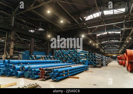 Molti tubi in acciaio blu per condutture d'acqua nel magazzino di fabbrica. Foto Stock