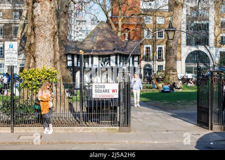 Persone che godono del tempo più caldo che arrivano nel Regno Unito, Soho Square, Londra, Regno Unito Foto Stock