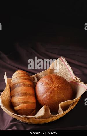 delizioso pane artigianale fatto in casa con grani naturali in un cestino di vimini Foto Stock