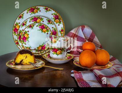 Bei piatti di porcellana cinese sul tavolo, caffè set torta, arance. L'odore di caffè e torta fresca la sera. Foto Stock