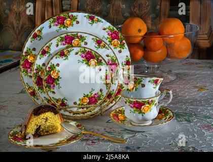 Bei piatti di porcellana cinese sul tavolo, caffè set torta, arance. L'odore di caffè e torta fresca la sera. Foto Stock