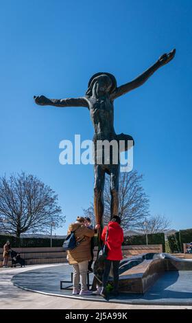 Persone che pregano ai piedi della statua di Cristo Risorto nel villaggio di Medjugorje, Bosnia-Erzegovina Foto Stock