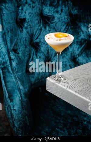 Pisco sour cocktail fatto in casa. Sour whiskey in coupé Glass con ghiaccio su sfondo grigio. Vista dall'alto, spazio di copia. Pubblicità per caffè. Menu bar Foto Stock