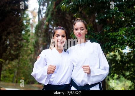 calci alti della gente durante l'addestramento di taekwondo all'aperto sfondo di bambù Foto Stock