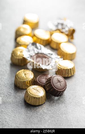 Praline di cioccolato avvolte. Boni di cioccolato dolce su un tavolo da cucina. Foto Stock