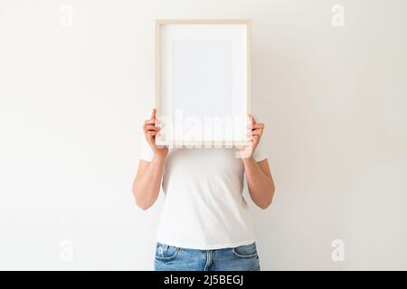 Una cornice in legno con spazio vuoto nelle mani delle donne Foto Stock